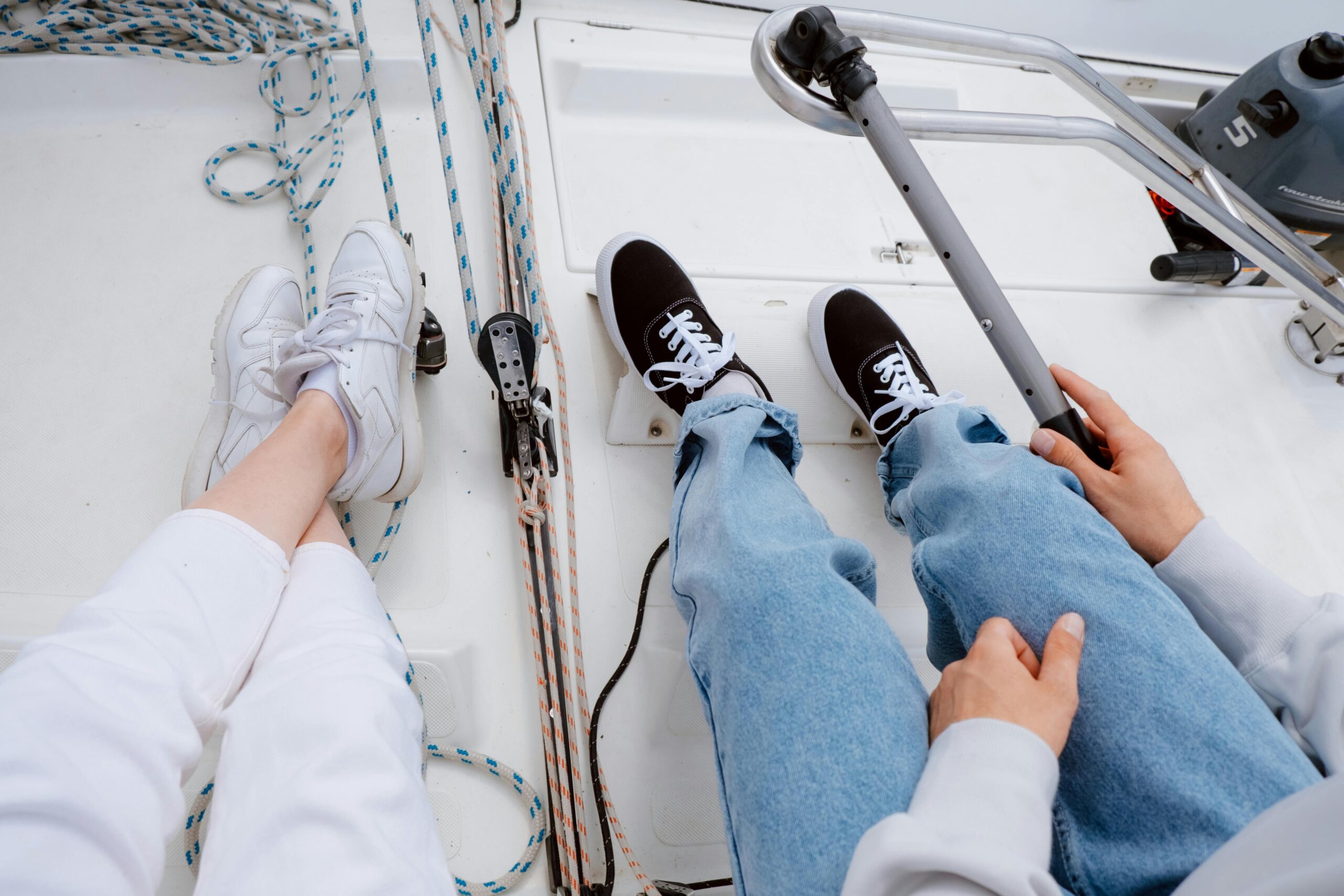 Two people relaxing on a yacht deck, capturing a serene sailing experience on the open sea.